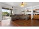 Spacious living room boasts hardwood floors, a ceiling fan, built-in shelves, and access to the screened patio at 110 Wekiva Pointe Cir, Apopka, FL 32712