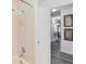 Bathtub shower with white tile and a view to the hallway with wood-look floors at 1148 Monroe Ave, St Cloud, FL 34769