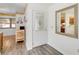 Bright entryway featuring laminate floors, white door, decorative mirror, and a glimpse into the kitchen at 1148 Monroe Ave, St Cloud, FL 34769