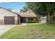 Charming single-story home with brick accents, manicured lawn, and mature trees on a sunny day at 1148 Monroe Ave, St Cloud, FL 34769