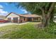 Lovely home with brick accents, a manicured lawn, and a beautiful mature tree in the front yard at 1148 Monroe Ave, St Cloud, FL 34769