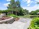 Beautiful backyard features a stone patio with a fire pit and lush landscaping near the pond at 116 Cherry Creek Cir, Winter Springs, FL 32708