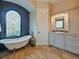 This bathroom has a free-standing tub, unique stained glass window, and an elegant vanity with granite countertops at 116 Cherry Creek Cir, Winter Springs, FL 32708