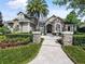 Inviting entryway featuring stone pillars and a beautifully landscaped walkway leading to the front door at 116 Cherry Creek Cir, Winter Springs, FL 32708