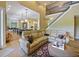 Open floorplan living room with view of the dining and kitchen areas, hardwood floors, and staircase to second story at 116 Cherry Creek Cir, Winter Springs, FL 32708