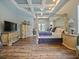 Primary bedroom features a tray ceiling, four-poster bed, wood-look flooring, and access to a private balcony at 116 Cherry Creek Cir, Winter Springs, FL 32708