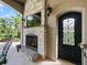 Outdoor fireplace with a stone surround, mounted TV, and elegant iron entry door at 116 Cherry Creek Cir, Winter Springs, FL 32708
