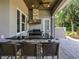 An outdoor kitchen with granite countertop, stainless steel grill, and barstool seating at 116 Cherry Creek Cir, Winter Springs, FL 32708