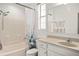All-white bathroom with a shower-tub combo, a large mirror, and vanity with storage underneath at 12016 Villanova Dr # 101, Orlando, FL 32837