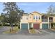 Exterior of a three-story townhome with three garages and a mix of beige and yellow paint at 12016 Villanova Dr # 101, Orlando, FL 32837