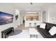 Open-concept living room featuring a mounted TV, a comfortable sofa, and a kitchen view at 12016 Villanova Dr # 101, Orlando, FL 32837