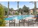 Community pool with palm trees and lounge chairs, creating a resort-style living environment at 12016 Villanova Dr # 101, Orlando, FL 32837