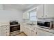 Updated kitchen featuring stainless steel appliances, white cabinets, and a stainless steel sink at 1236 Villa Ln # 143, Apopka, FL 32712