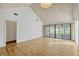 Bright living room featuring a vaulted ceiling, hardwood floors, and sliding glass doors to the sunroom at 1236 Villa Ln # 143, Apopka, FL 32712