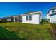 View of the home's manicured lawn and clean white exterior, complete with a covered patio area, from the side yard at 13301 Mcmillan Dr, Orlando, FL 32827