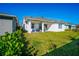 Expansive backyard featuring lush green grass, a covered patio and white exterior paint with a well-maintained garden at 13301 Mcmillan Dr, Orlando, FL 32827