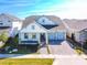 Charming home with a two-car garage, gray accents, a covered porch, and a well-maintained brick driveway and front yard at 13301 Mcmillan Dr, Orlando, FL 32827