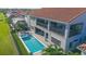 Aerial view of a luxurious two-story house showcasing a beautiful swimming pool and outdoor living spaces at 13307 Alderley Dr, Orlando, FL 32832