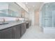 Bathroom showcasing a large walk-in shower, double vanity, granite countertops, and modern lighting at 13307 Alderley Dr, Orlando, FL 32832