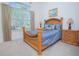 Bedroom boasting a wood bed frame, side table, and a large window providing natural light at 13307 Alderley Dr, Orlando, FL 32832