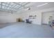 This oversized three-car garage is equipped with epoxy flooring, bright lighting, and plenty of room for storage at 13307 Alderley Dr, Orlando, FL 32832