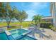 A luxurious hot tub with a serene waterfall feature, complemented by a lush, landscaped backyard at 13307 Alderley Dr, Orlando, FL 32832