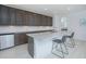 Modern kitchen featuring dark cabinets, granite countertops, stainless steel appliances, and seating for two at 13307 Alderley Dr, Orlando, FL 32832