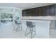 Modern kitchen featuring dark cabinets, granite countertops, stainless steel appliances, and seating for two at 13307 Alderley Dr, Orlando, FL 32832
