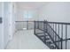 Bright upstairs landing featuring a decorative wrought iron banister and a window, creating an inviting transition between floors at 13307 Alderley Dr, Orlando, FL 32832