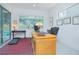 Home office with a large wooden desk, comfortable seating, natural light, and view of a pool at 13307 Alderley Dr, Orlando, FL 32832