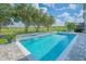 Swimming pool features a waterfall and spa, with views of the lush green golf course and blue sky at 13307 Alderley Dr, Orlando, FL 32832