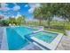 Inviting backyard oasis featuring a pool, spa, and lush landscaping with neighborhood view at 13307 Alderley Dr, Orlando, FL 32832