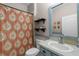 Bathroom with patterned curtain, decorative shelves, vanity with mirror, and blue trim at 13326 Fountainbleau Dr, Clermont, FL 34711