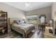 Cozy bedroom features wood-look floors, a ceiling fan, and a tranquil view from the window at 13326 Fountainbleau Dr, Clermont, FL 34711