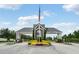 Community entrance featuring decorative landscaping and an American flag at 13326 Fountainbleau Dr, Clermont, FL 34711