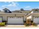 Attractive townhouse featuring a two-car garage, manicured landscaping, and a secure gated entrance at 13326 Fountainbleau Dr, Clermont, FL 34711
