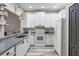 Well-lit kitchen features white cabinets, gray counters and wood-look flooring at 13326 Fountainbleau Dr, Clermont, FL 34711
