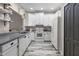 Well-lit kitchen features white cabinets, gray counters and wood-look flooring at 13326 Fountainbleau Dr, Clermont, FL 34711