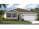 Charming one-story home featuring a manicured lawn and a two-car garage, complemented by a stone facade and neutral color palette at 1351 Wood Line Dr, Deland, FL 32720