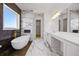 Luxurious bathroom with freestanding tub, marble floors and countertops, and dual mirrors at 15060 Brodie Ln, Winter Garden, FL 34787