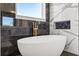 Luxurious bathroom with a freestanding tub, gold fixtures, and marble tiled walls at 15060 Brodie Ln, Winter Garden, FL 34787