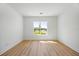 Bright and airy bedroom features wood floors and a large window with a neighborhood view at 15060 Brodie Ln, Winter Garden, FL 34787