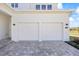 Two-car garage with classic white doors and brick-paved driveway, offering convenience at 15060 Brodie Ln, Winter Garden, FL 34787