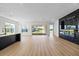 Bright, open-concept living room featuring modern fireplace, wood floors, and sliding glass doors to the backyard at 15060 Brodie Ln, Winter Garden, FL 34787