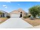 Well-maintained home featuring a front yard, two-car garage, and stucco facade at 15746 Autumn Glen Ave, Clermont, FL 34714