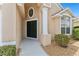 Close up of home's front entrance with a column, garden bed, and arched window at 15746 Autumn Glen Ave, Clermont, FL 34714