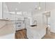 Bright kitchen with white cabinets, stone countertops, stainless steel appliances, and tile backsplash at 15746 Autumn Glen Ave, Clermont, FL 34714