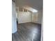 Bright living room featuring vaulted ceilings, wood-look floors, and large windows that provide plenty of natural light at 15746 Autumn Glen Ave, Clermont, FL 34714