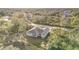 An aerial view of the house displays its backyard, gray roof, and proximity to trees and other houses at 1639 Pickerel Ct, Kissimmee, FL 34759