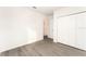 Minimalist bedroom featuring gray wood floors, white walls, and a large closet for storage at 1639 Pickerel Ct, Kissimmee, FL 34759